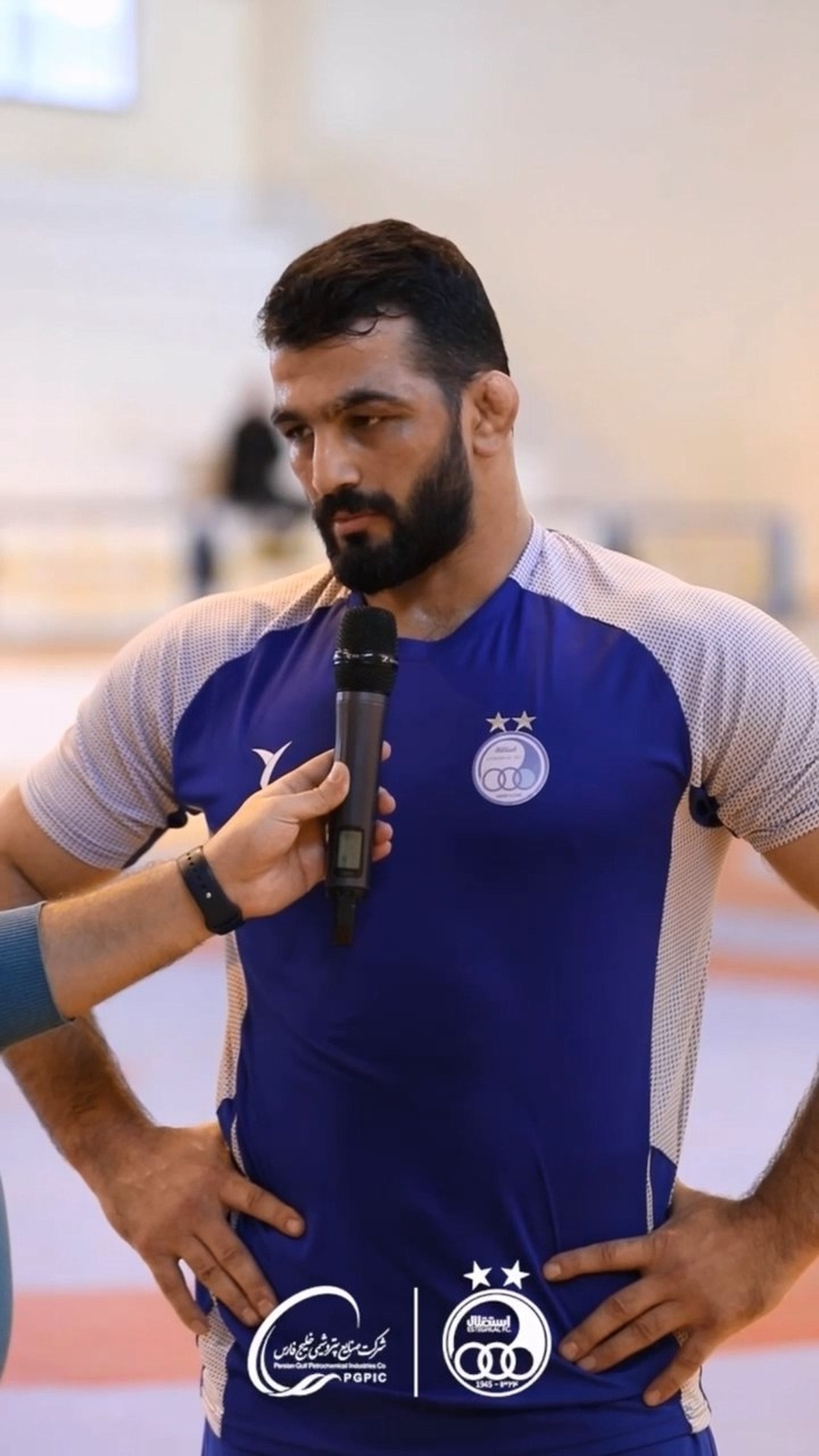 حسن یزدانی با پیراهن آبی روی تشک کشتی میرود